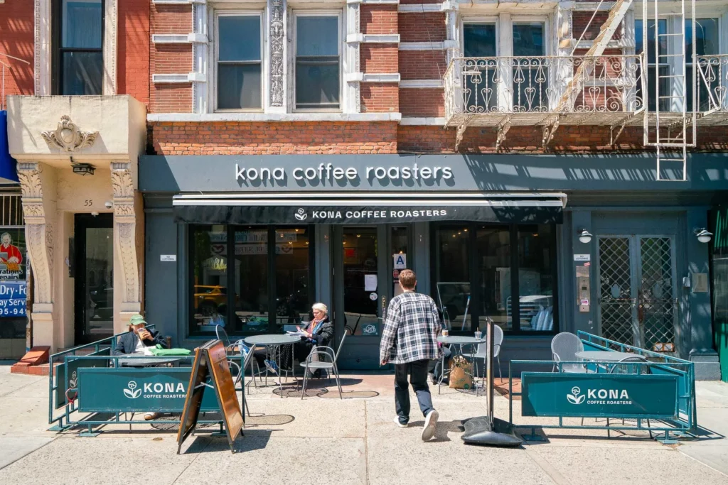 Interior of Kona Coffee Roasters in East Village, NYC, featuring a minimalist design and baristas preparing fresh Kona coffee.