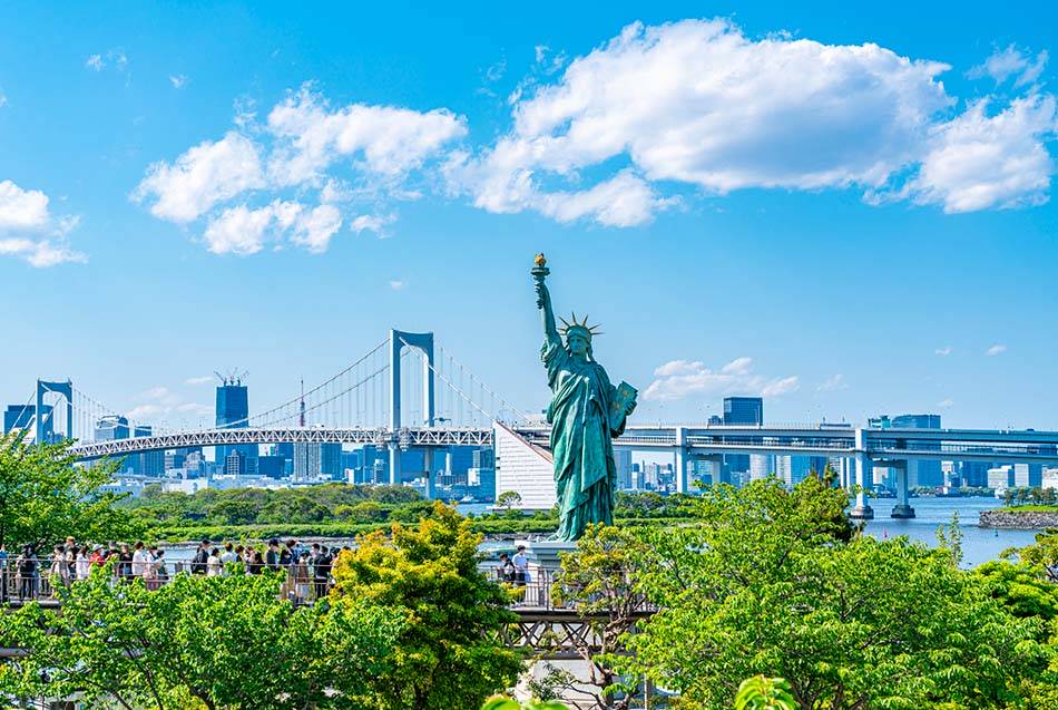 The futuristic skyline of Odaiba, featuring the Rainbow Bridge and a life-sized Gundam statue.
